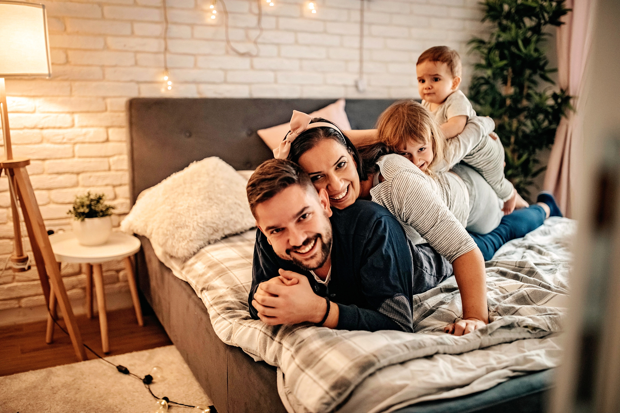 Young and happy family playing in bedroom